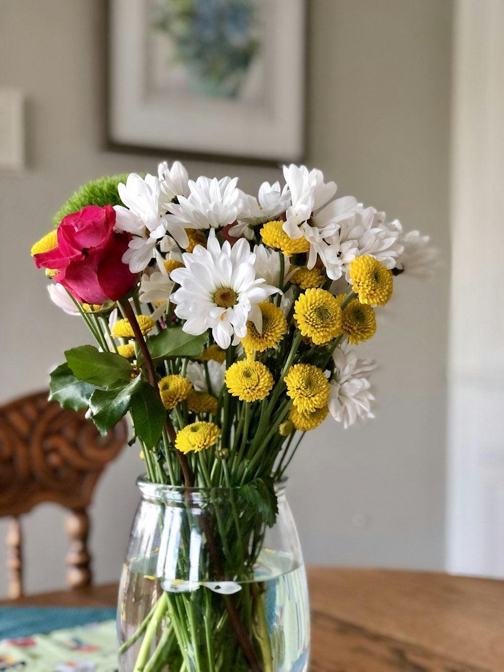 un vaso pieno di fiori seduto sopra un tavolo di legno