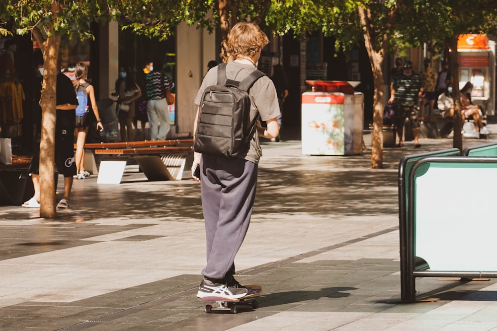 um menino que anda de skate por uma calçada
