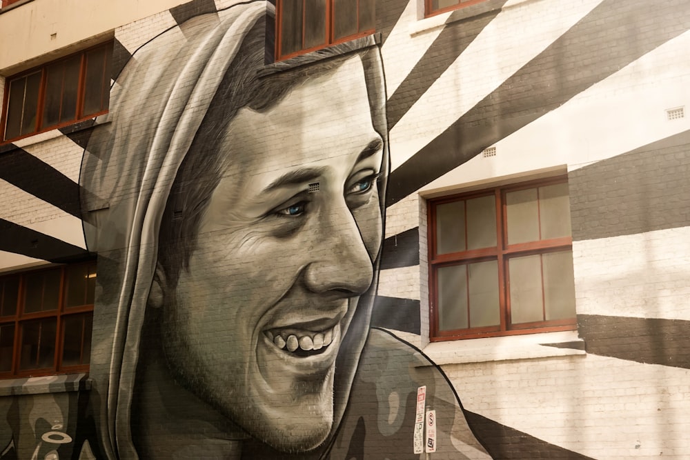 um grande mural de um homem sorridente ao lado de um edifício