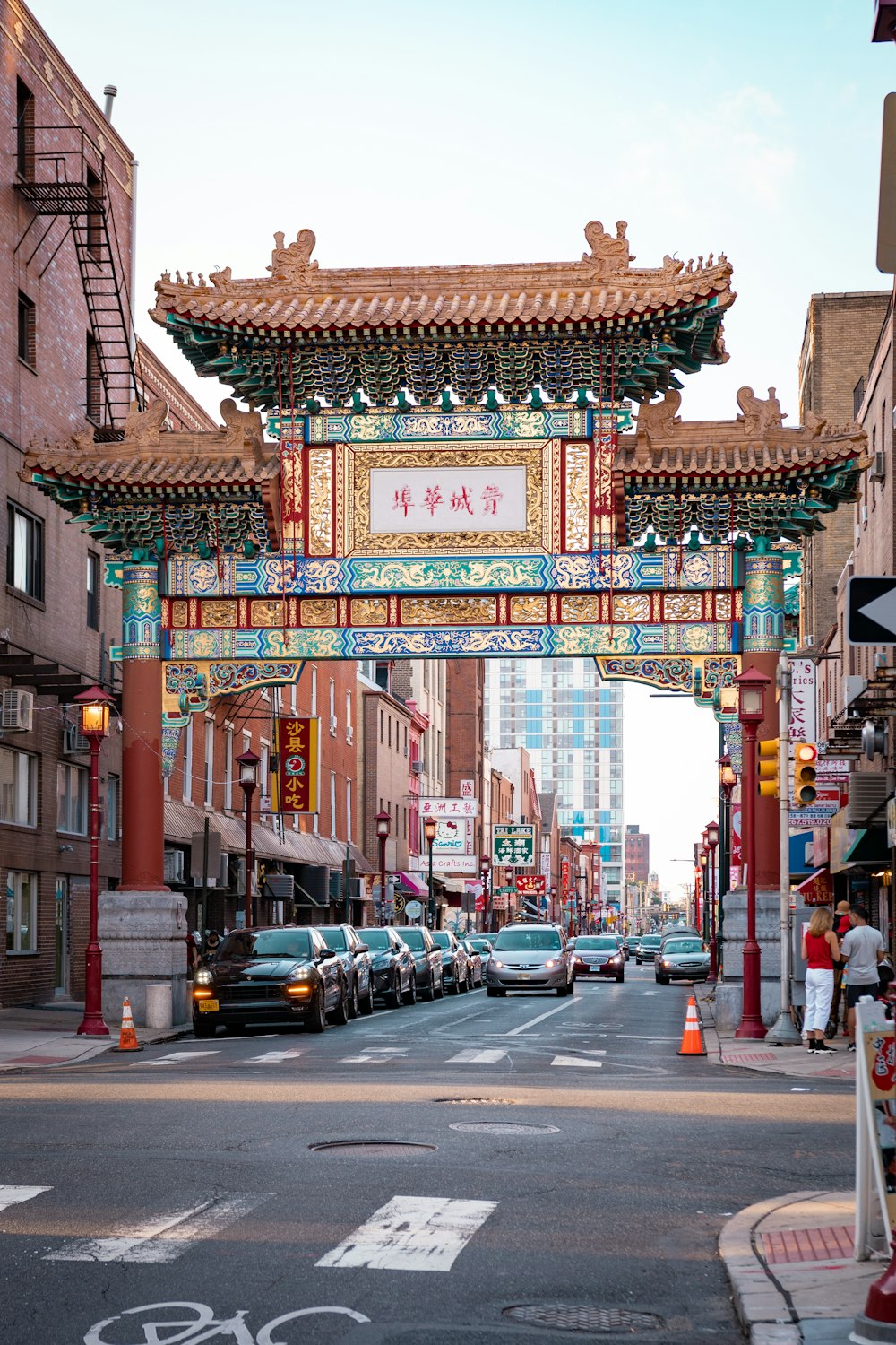 a city street with a chinese archway and cars parked on the side of the road