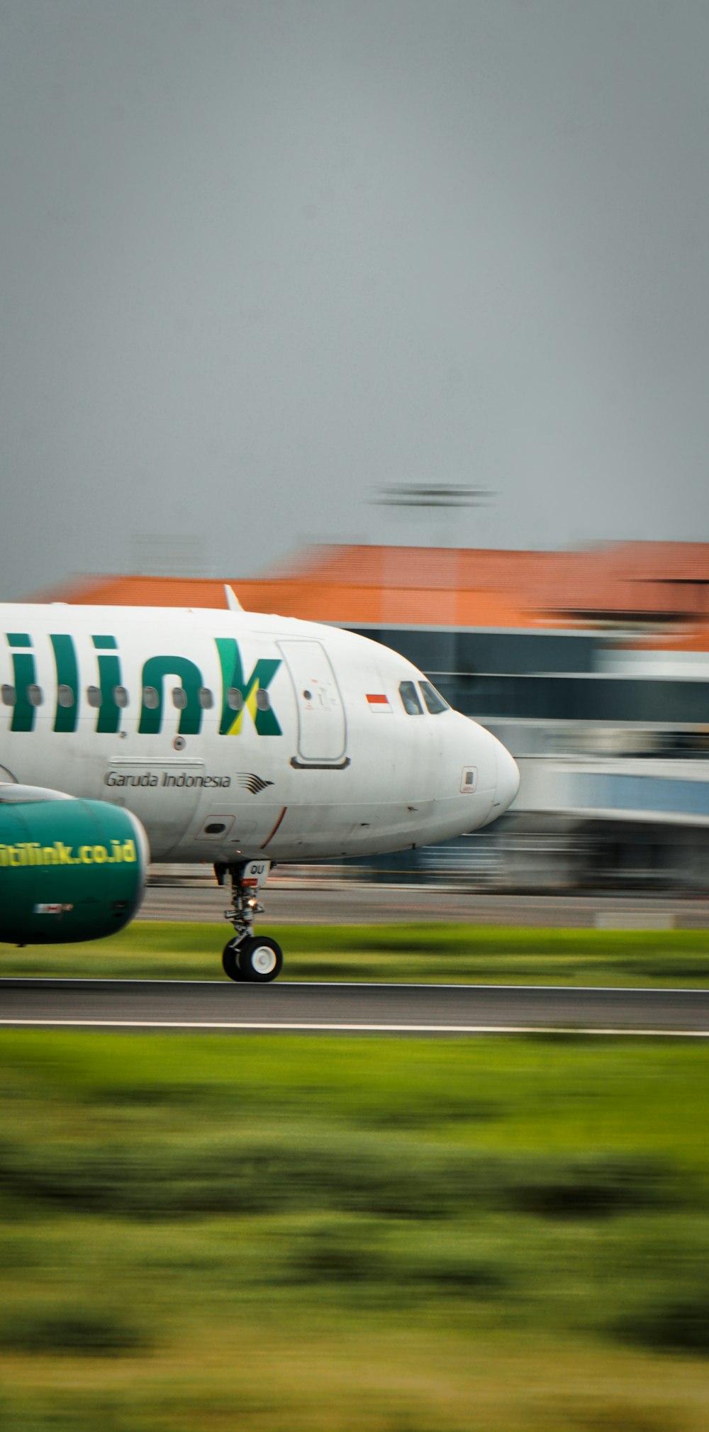 a white and green airplane is on a runway