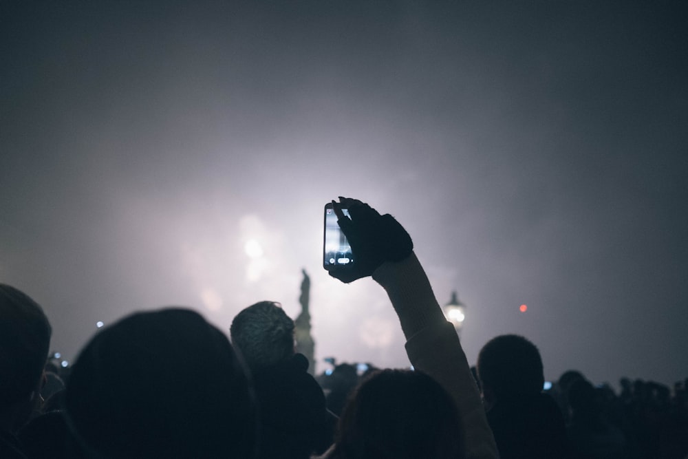 a person taking a picture of fireworks with a cell phone