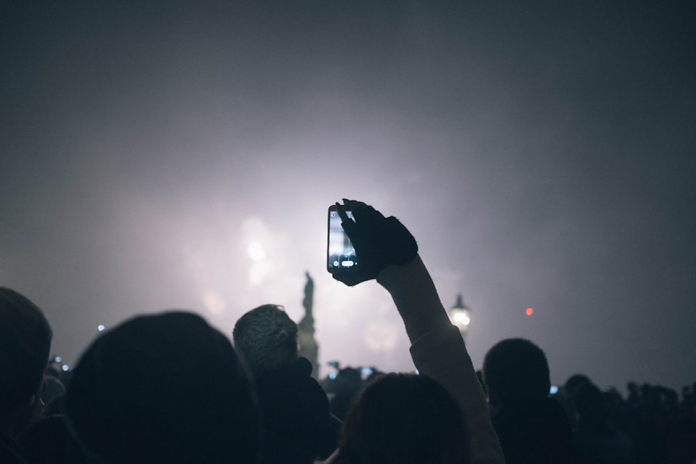 une personne prenant une photo de feux d’artifice avec un téléphone cellulaire