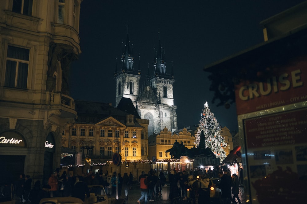 a crowd of people standing around a christmas tree