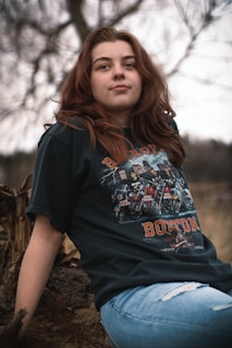 a woman sitting on a log in a field