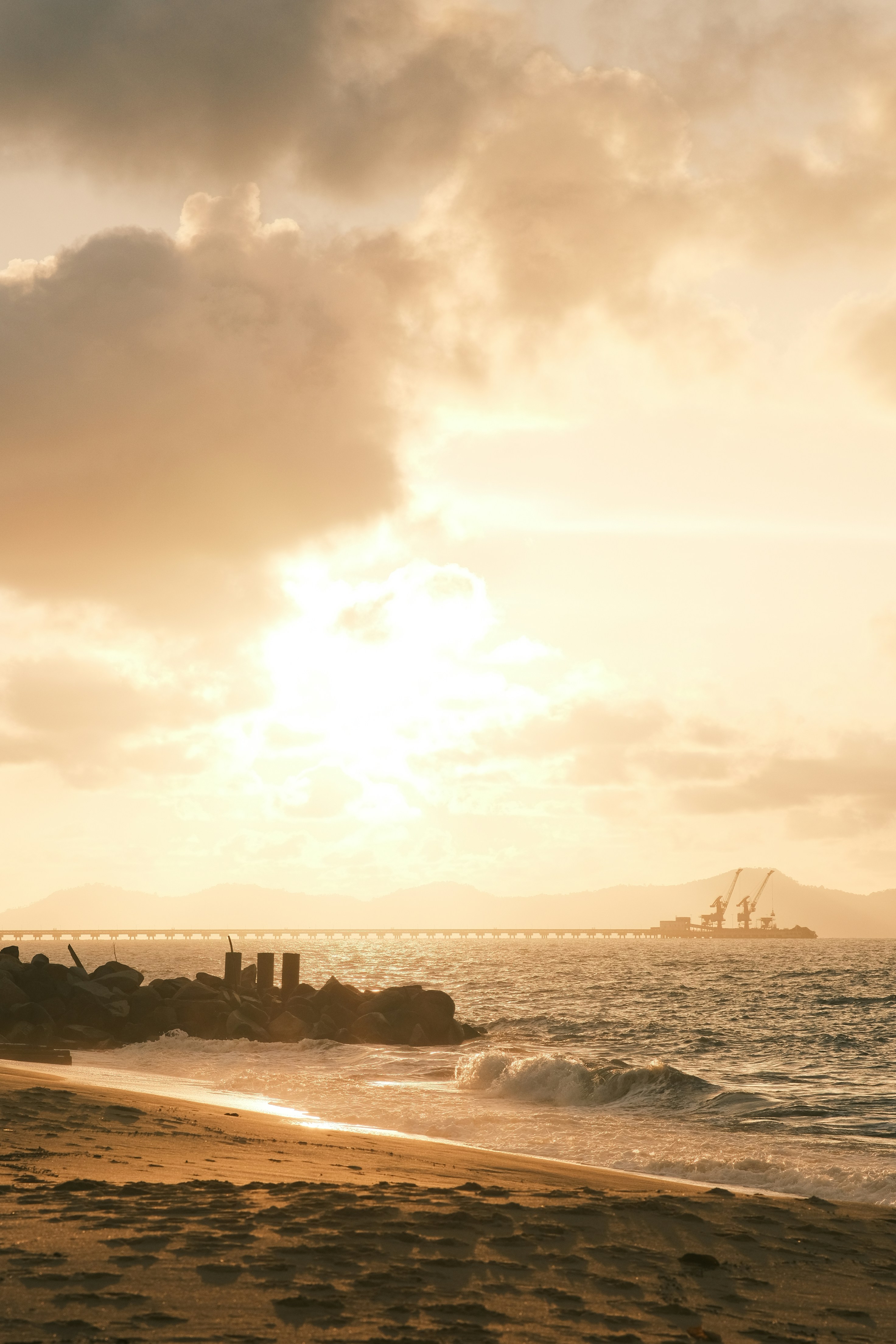 the sun is setting over the ocean with a boat in the distance