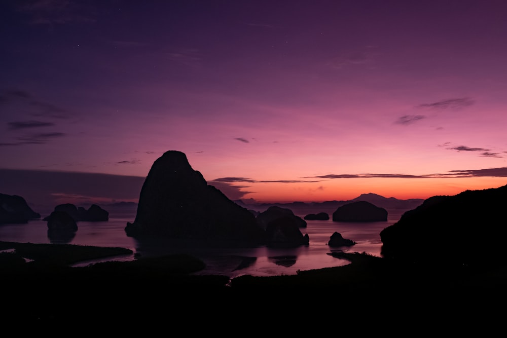 a purple and purple sunset over a body of water