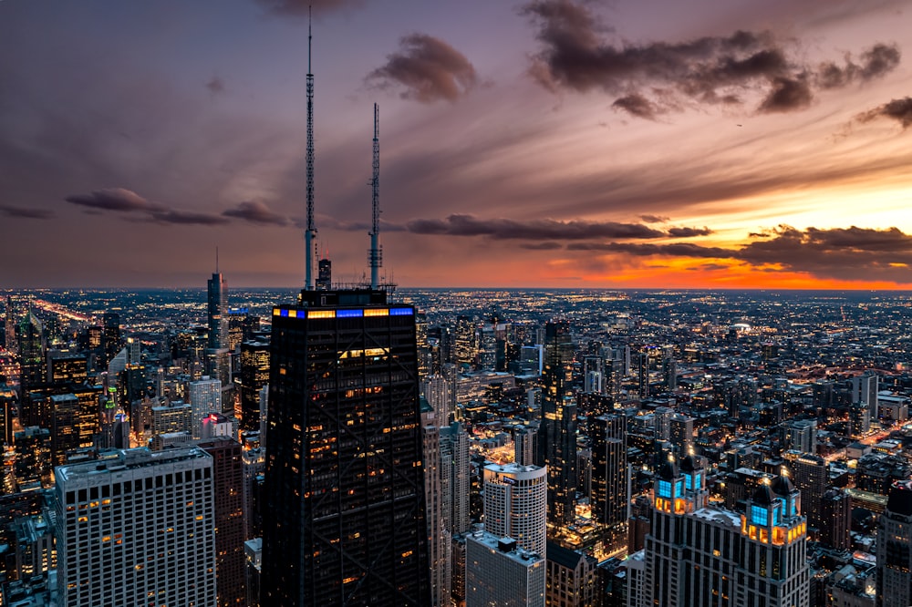 uma vista de uma cidade à noite do topo de um arranha-céu