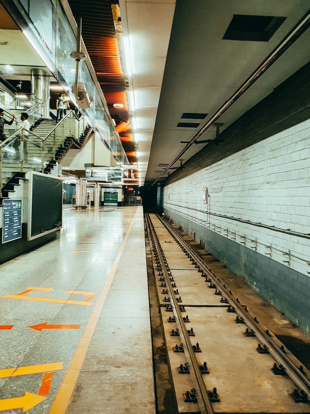 a train track in a train station next to a wall