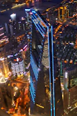 A sleek nighttime aerial shot of a luxury real estate property illuminated with blue accent lighting.