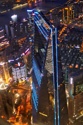 A sleek drone-shot cityscape glowing under electric blue night lights.