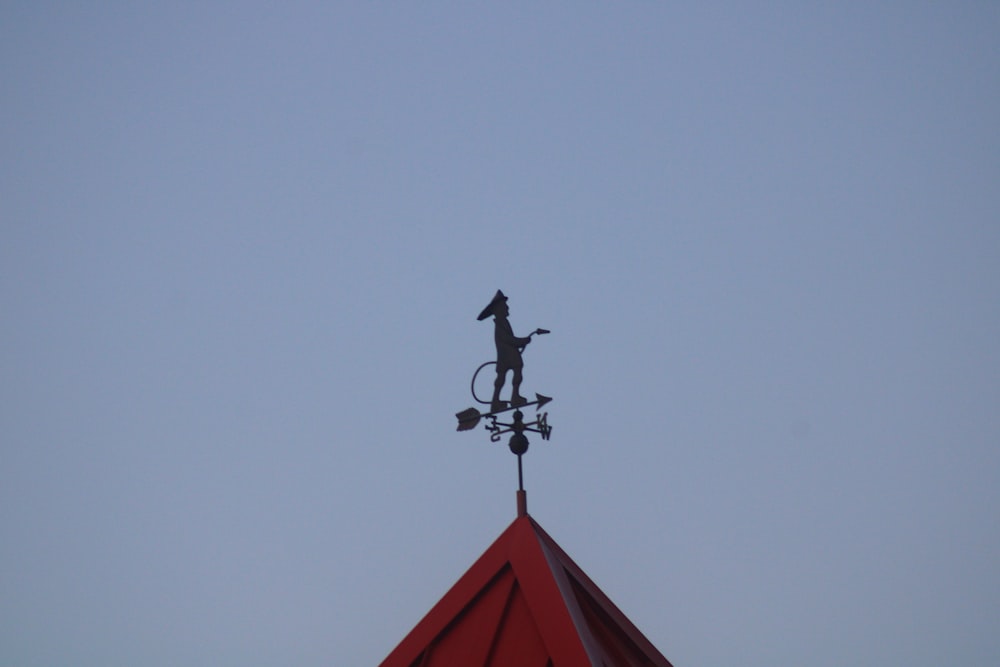 a statue of a man on a bicycle on top of a building