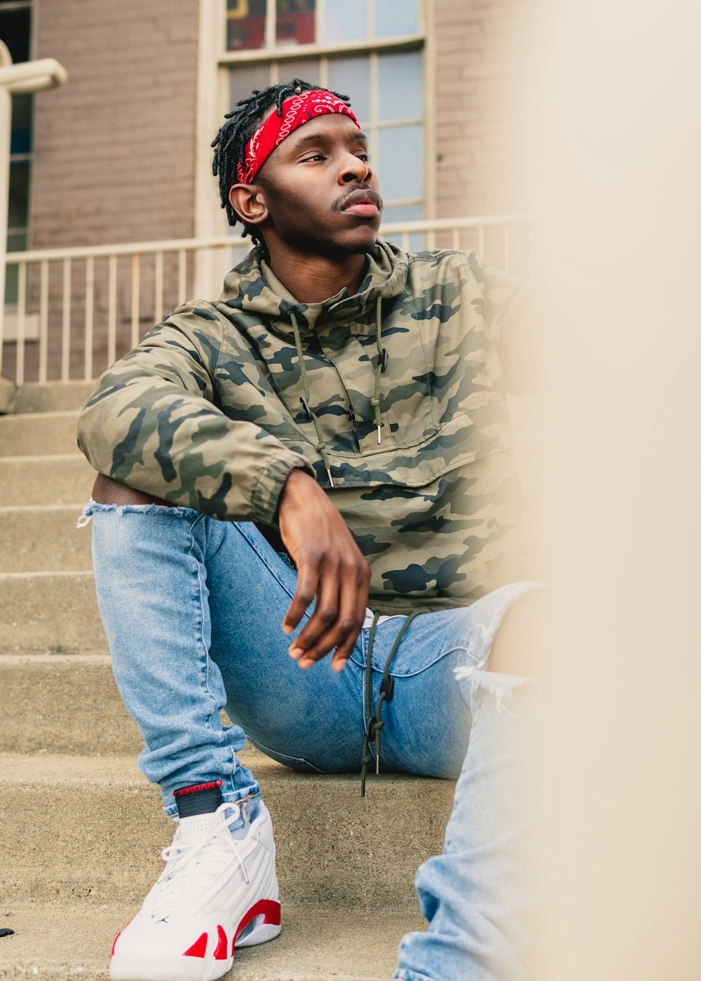 a young man sitting on the steps of a building