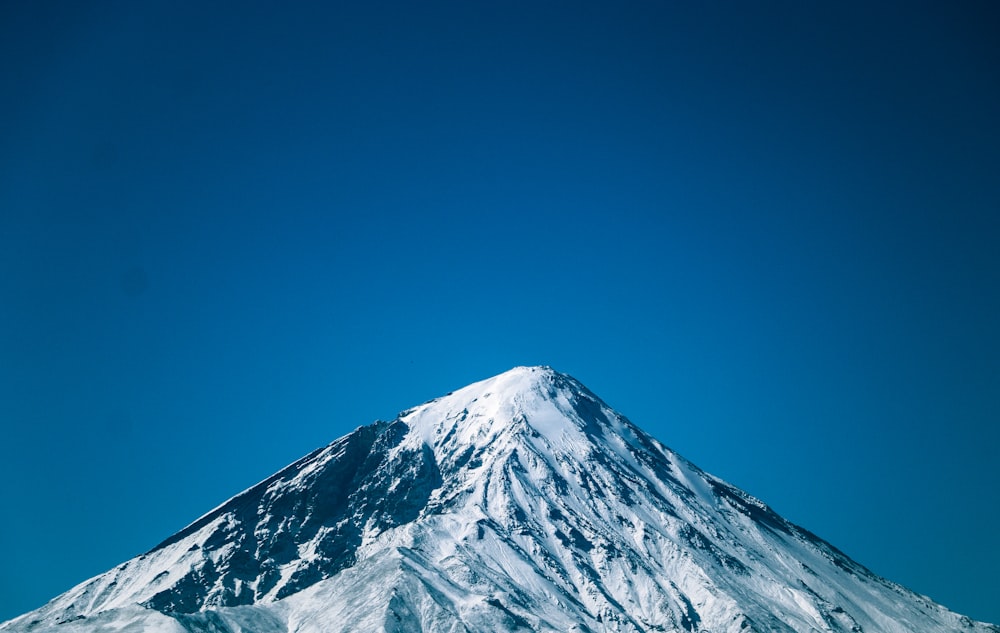 a snow covered mountain under a blue sky