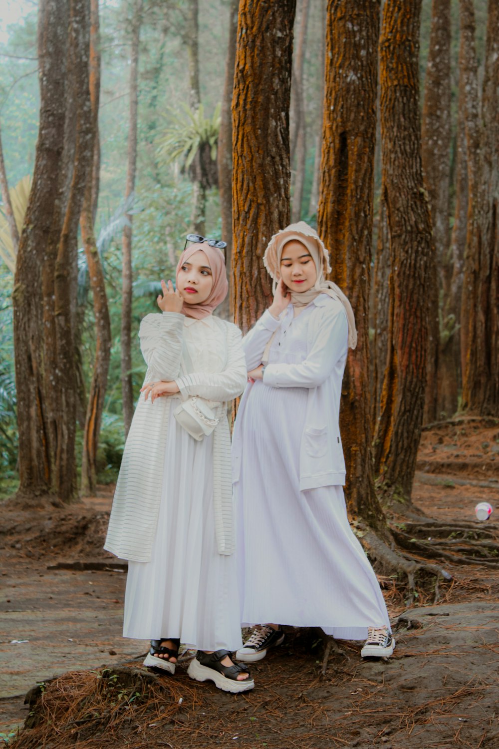 two women dressed in white standing next to each other