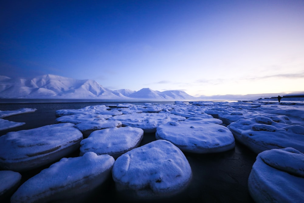 a beach covered in lots of snow covered rocks