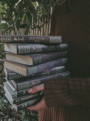 A smiling person holding a newly delivered stack of books from Nice Reads.