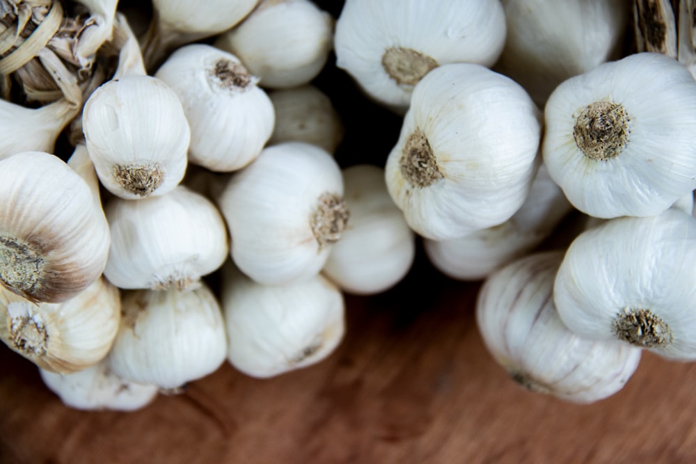 a bunch of garlic sitting on top of a wooden table