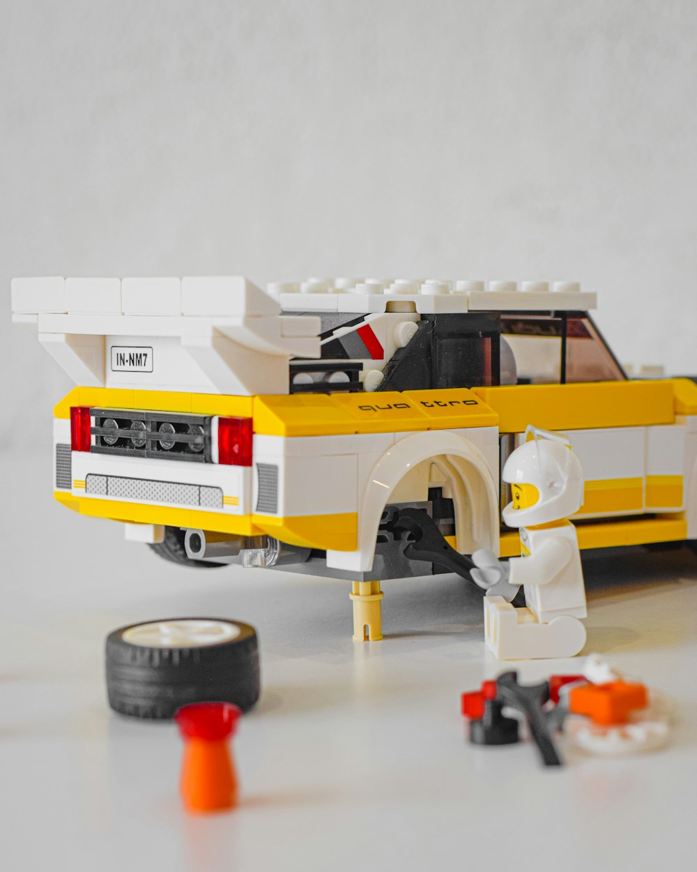 a yellow and white lego car with a man next to it