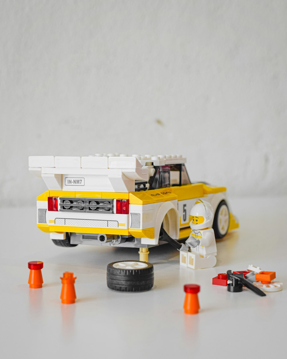 a toy truck with a lego car on the back of it