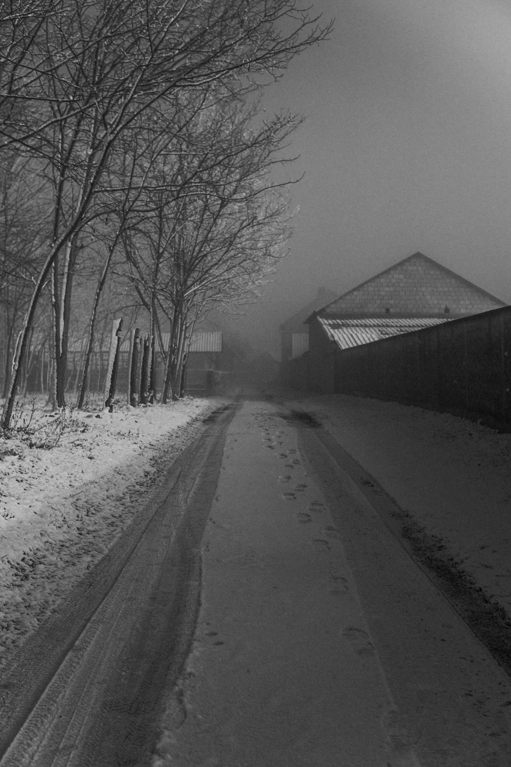 a black and white photo of a snowy road