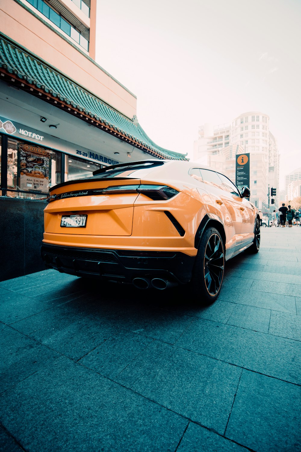 an orange sports car parked in front of a building