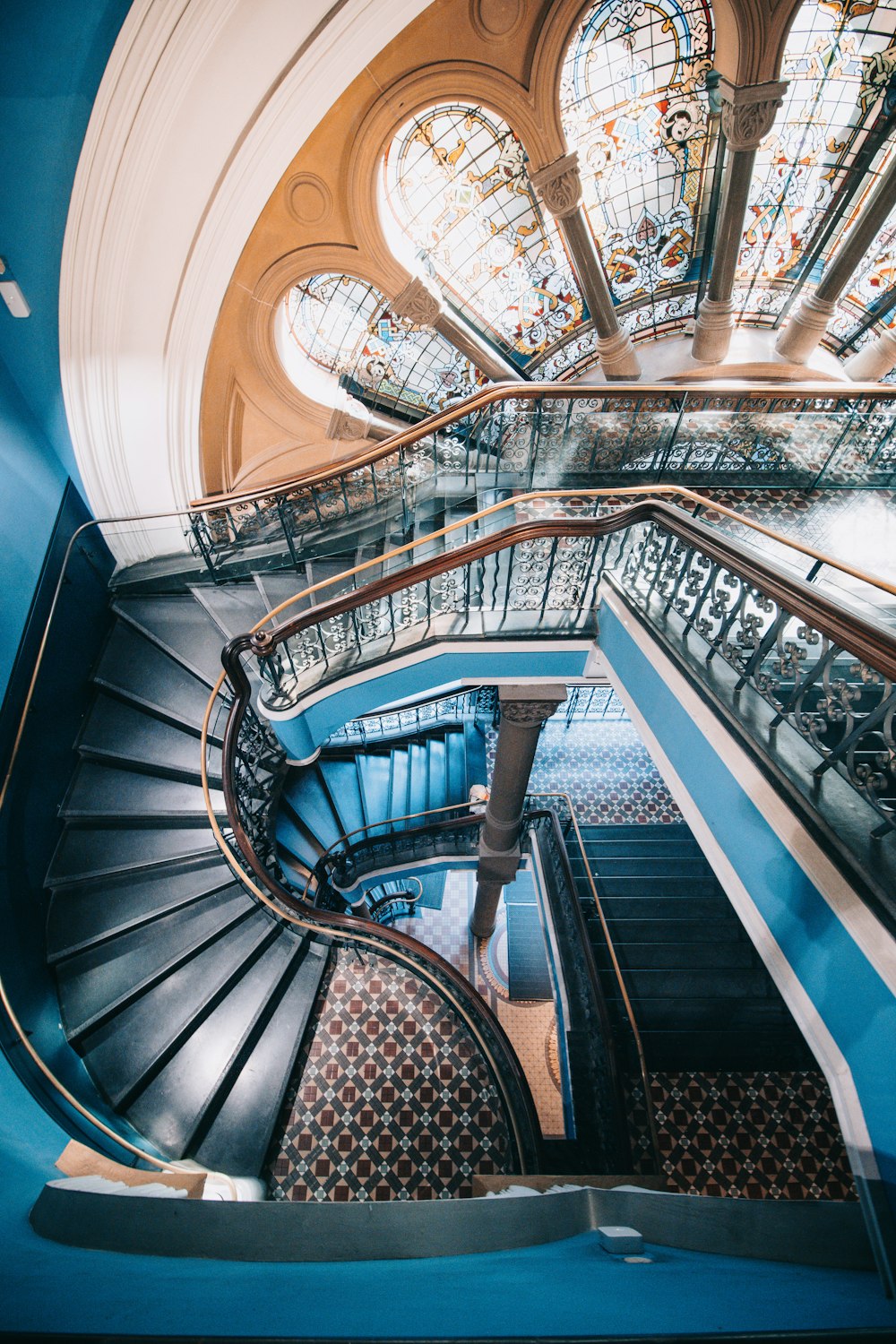 a spiral staircase in a building with stained glass windows