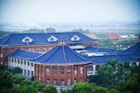a large building with a blue roof surrounded by trees