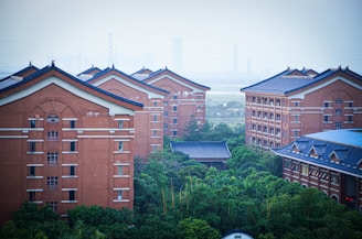 a group of red brick buildings surrounded by trees