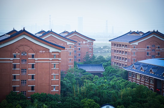 a group of red brick buildings surrounded by trees