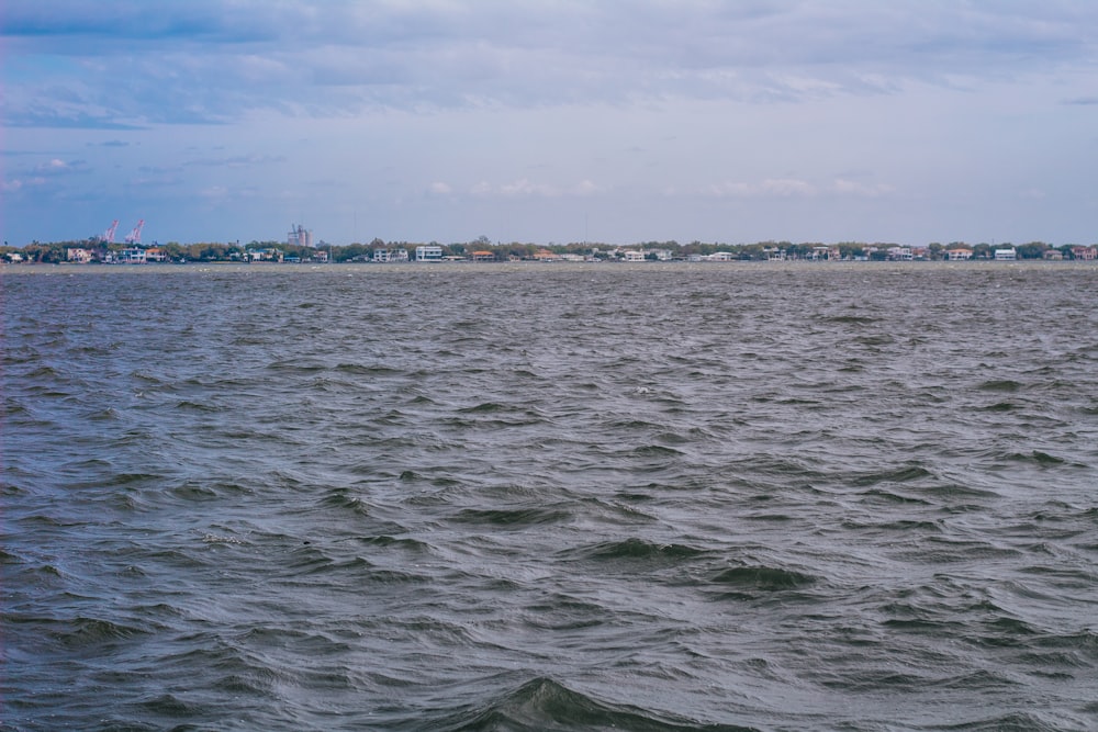 a large body of water with houses in the distance