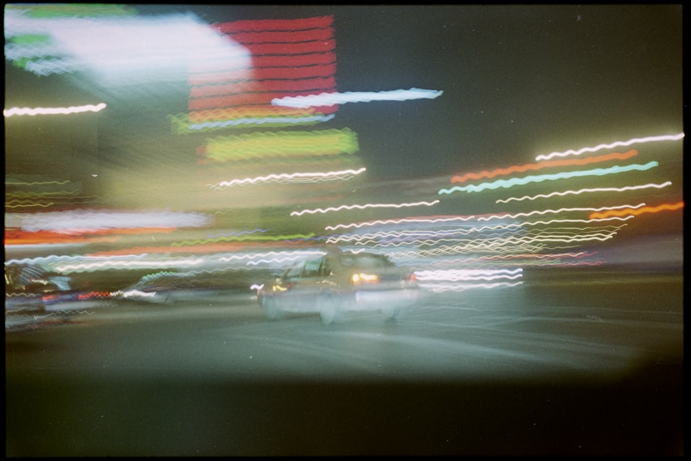 a blurry photo of a car driving down a street