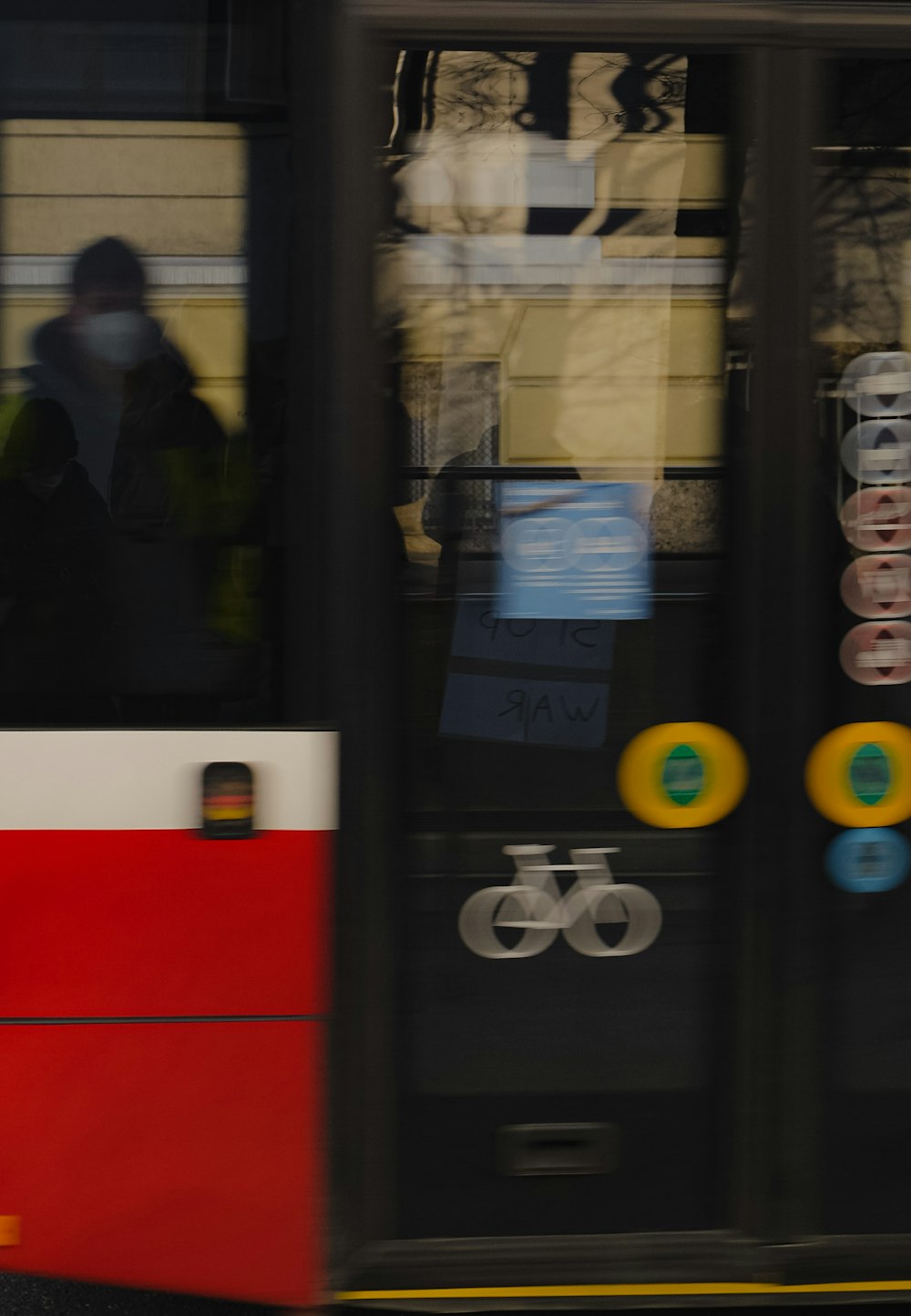 a red and white bus driving past a tall building