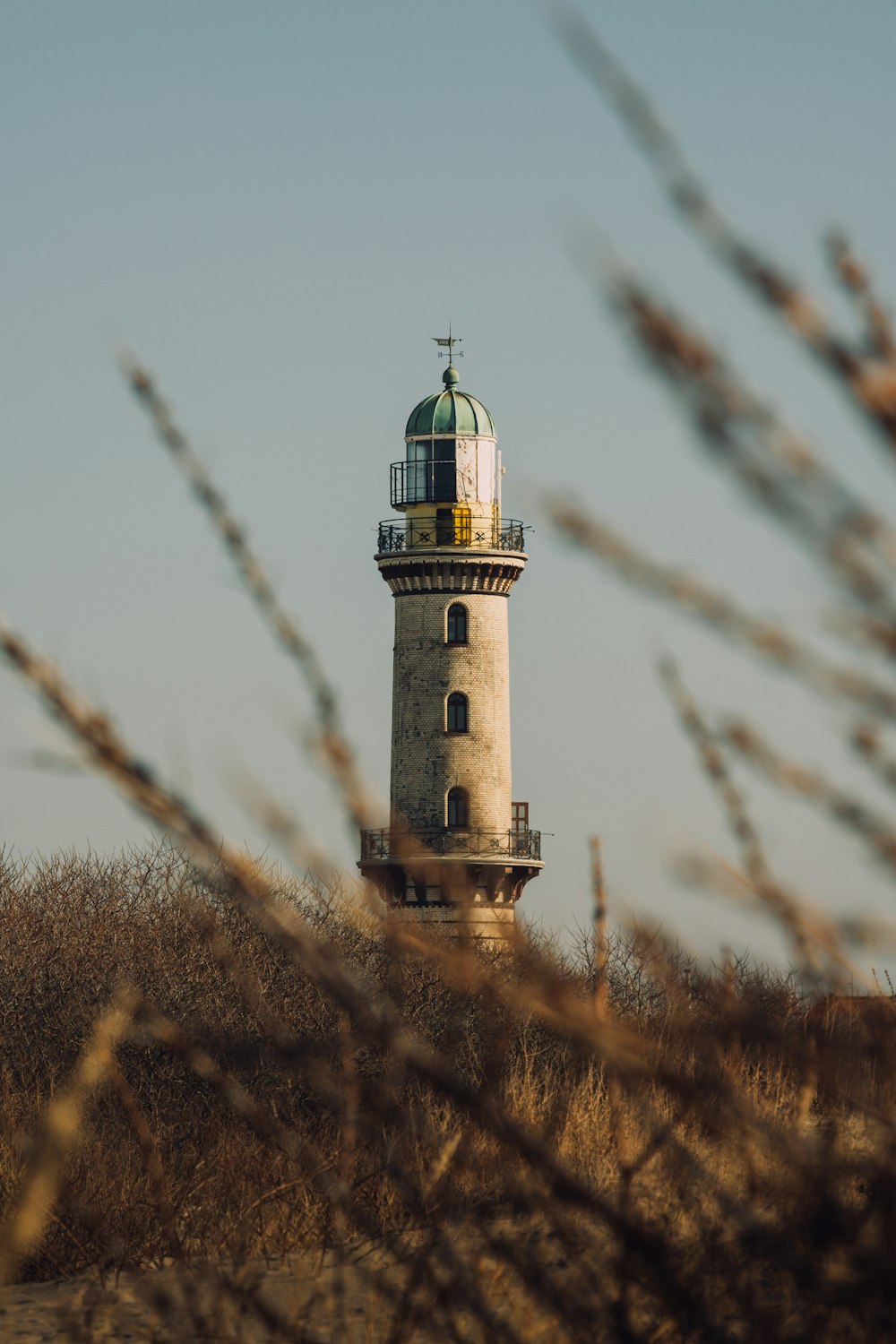 a tall light house sitting on top of a hill