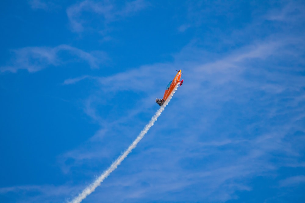 a small airplane flying through a blue sky