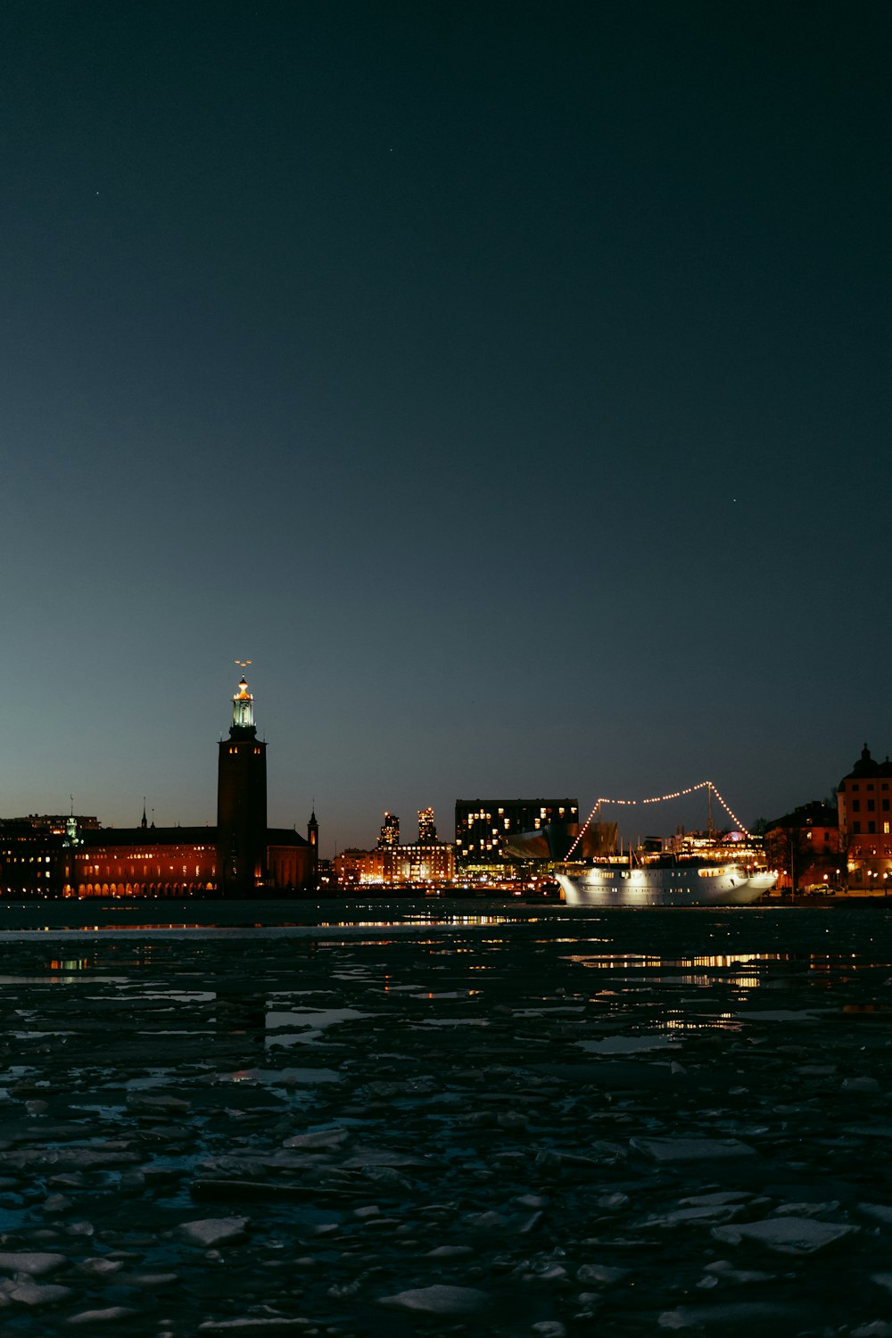 a large body of water at night with a clock tower in the background
