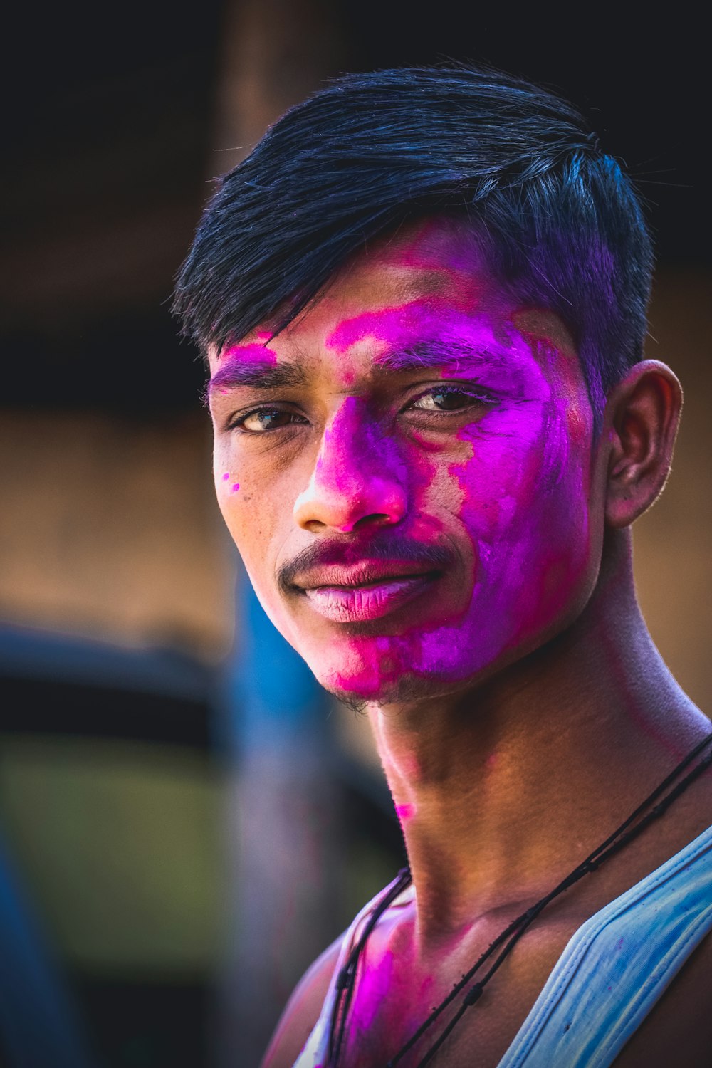 a man with a pink face and purple paint on his face
