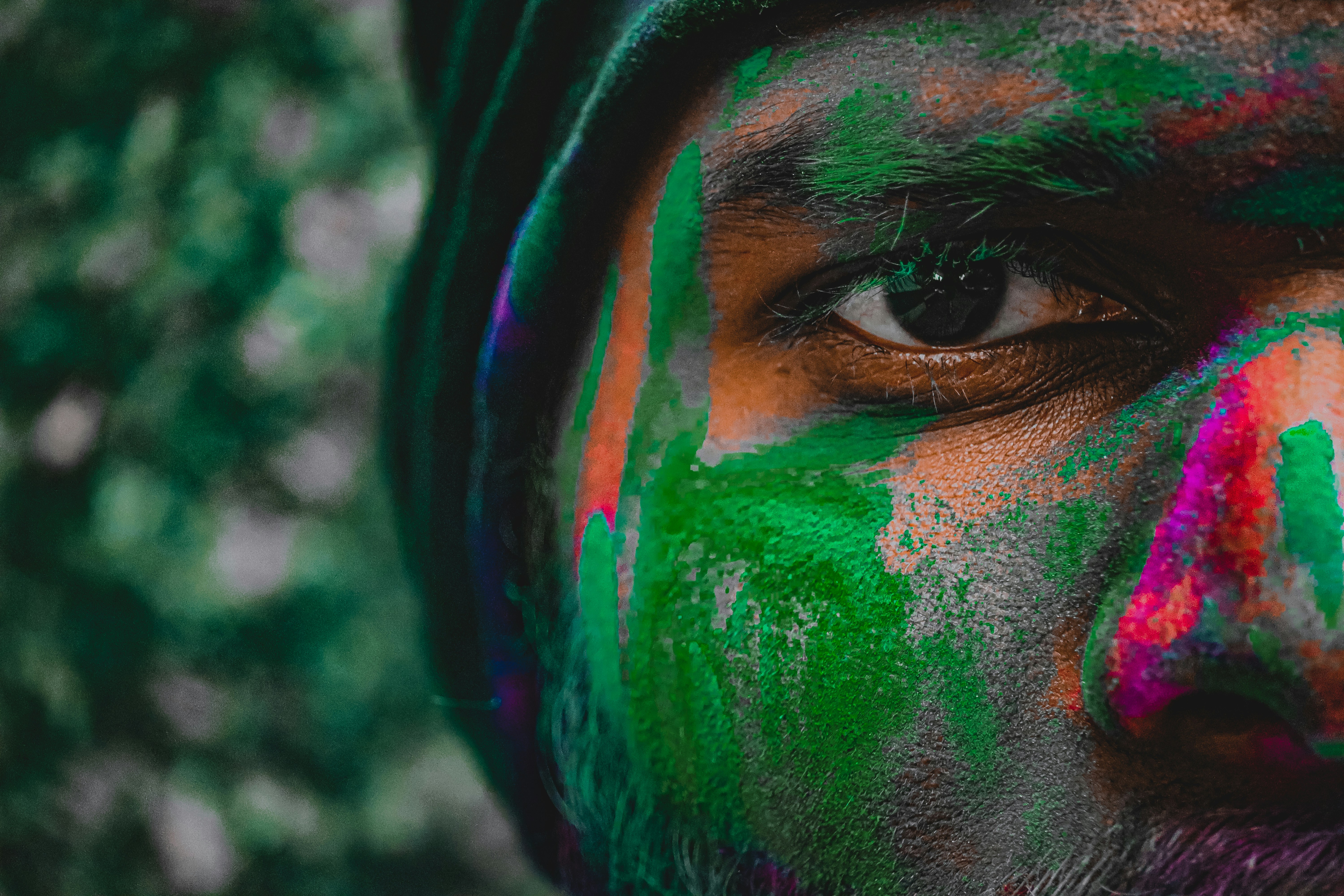 a close up of a man's face with colorful paint all over his face