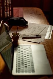 a laptop computer sitting on top of a wooden table