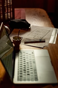 a laptop computer sitting on top of a wooden table