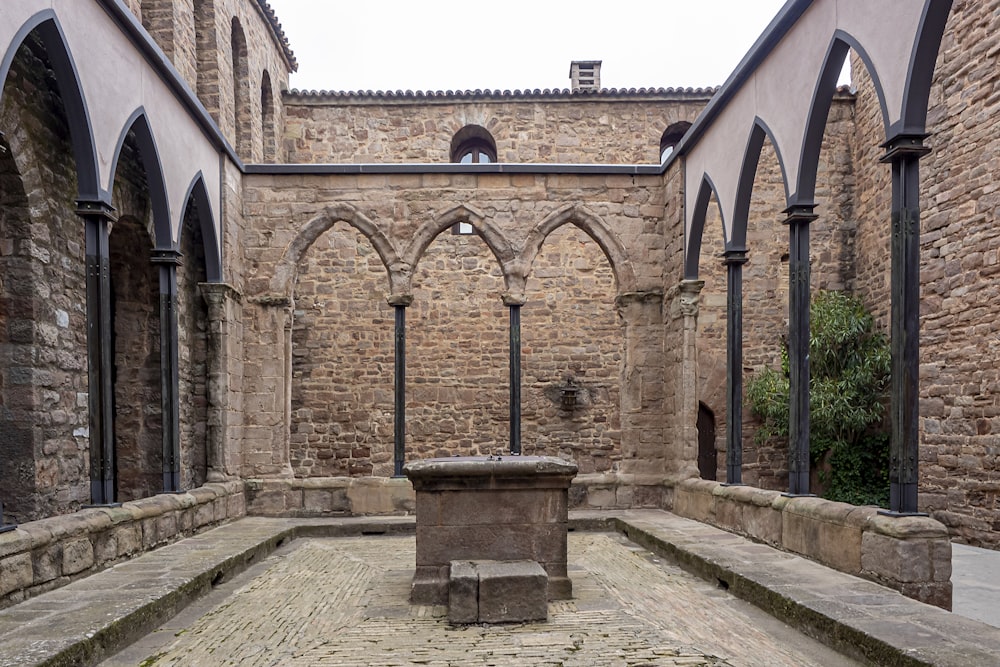 a stone courtyard with benches and arches