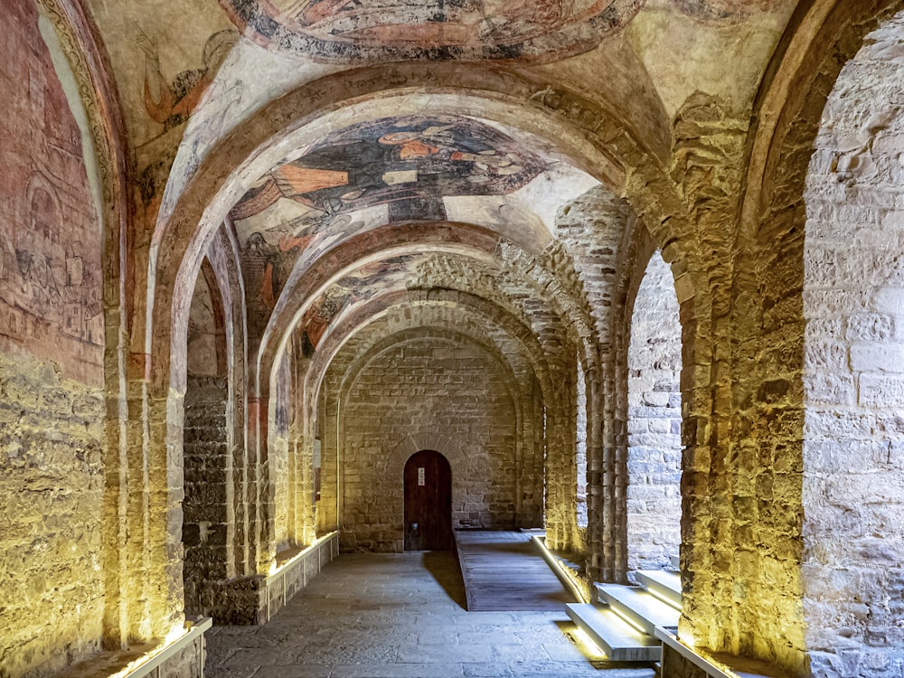 a long hallway with benches and paintings on the walls