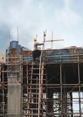 a man on a scaffold working on a building