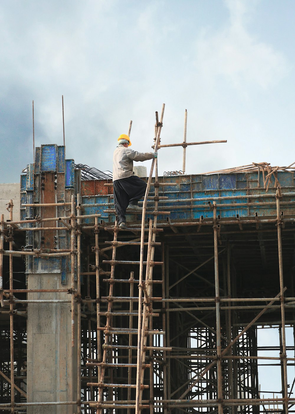 a man on a scaffold working on a building