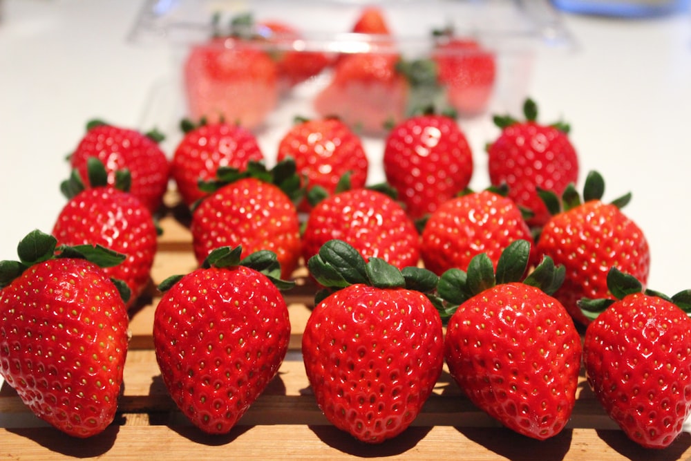 a group of strawberries sitting on top of a wooden cutting board
