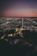 a view of a city at night from the top of a hill
