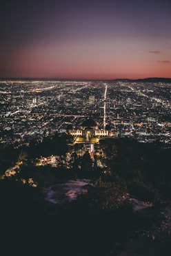 a view of a city at night from the top of a hill