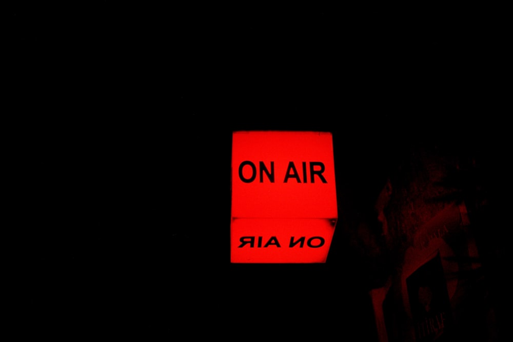 a red sign that says on air on a black background
