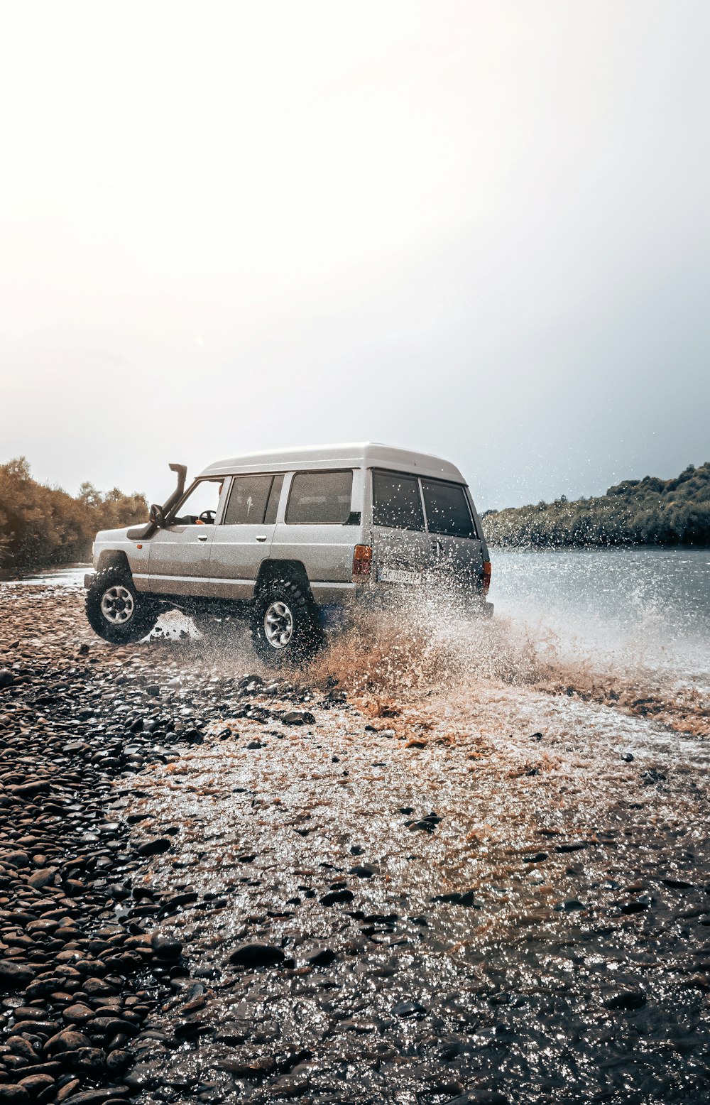 a white van driving through a body of water