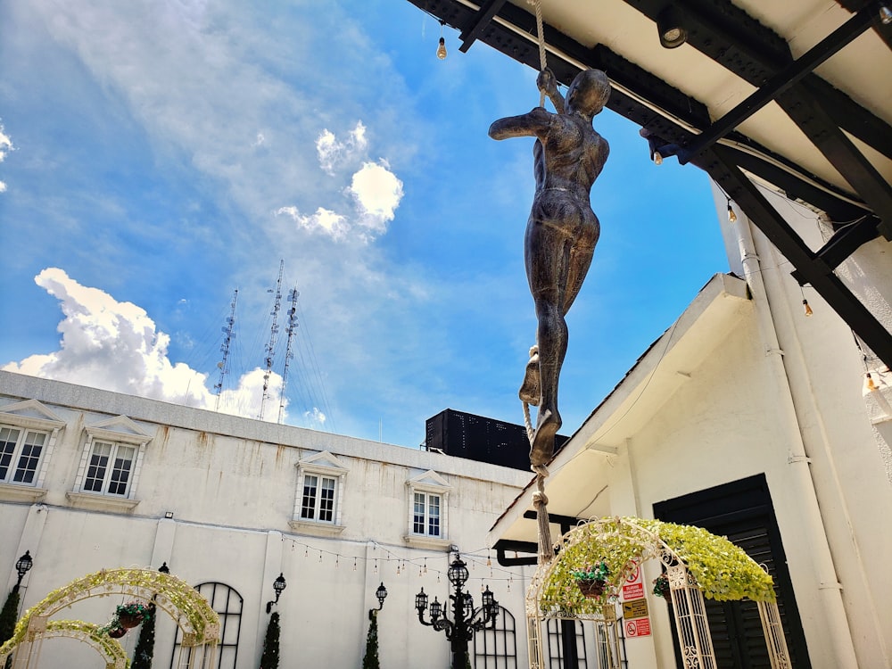 a statue of a man hanging from a roof